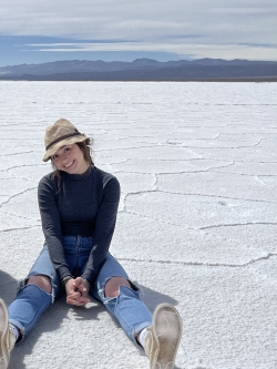 Alex Rego smiling while sitting on the salt flats of Buenos Aires.